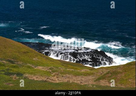 Ein Blick auf die Folgen der brechenden Wellen auf den Felsen in der Nähe der Nobbies auf Phillip Island, Victoria, Australien. Bass Strait ist berühmt für raue Meere. Stockfoto