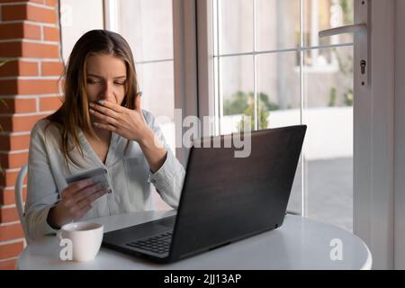 Besorgte Frau, die Probleme hat, online mit Kreditkarte und Laptop im Café zu bezahlen. Frau hat Kreditkarten, fühlt sich gestresst über Steuern und Schulden Stockfoto