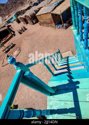 Ferienhaus in einem Beduinenlager am Meer in Ras Shitan in Oasis im Sinai, Taba Wüste mit dem Hintergrund des Meeres und der Berge. Stockfoto