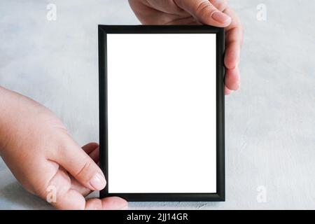 Der Bilderrahmen hält sich zärtlich in den Händen Stockfoto