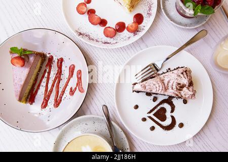 Auswahl an natürlichen veganen, geschichteten Desserts, Stück Kuchen mit frischen Früchten und Beeren im Café. Feier, Auswahl von Kuchen auf der Terra Stockfoto