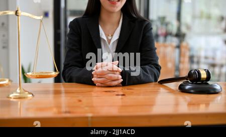Geballte Rechtsanwältin oder Rechtsberaterin am Tisch sitzend, in ernsthafte Verhandlungen oder Vertragsdiskussionen im modernen Büro verwickelt. Zugeschnittenes Bild Stockfoto
