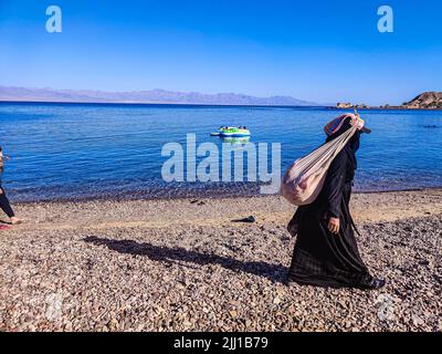 Ferienhaus in einem Beduinenlager am Meer in Ras Shitan in Oasis im Sinai, Taba Wüste mit dem Hintergrund des Meeres und der Berge. Stockfoto