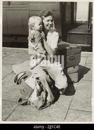 Ein Vintage-Foto um den Februar 1942, das eine britische Frau zeigt, die während der japanischen Invasion von Malaya und dem Fall von Singapur mit ihrem Baby auf dem Bahnhof von Ipoh evakuiert wurde. Stockfoto