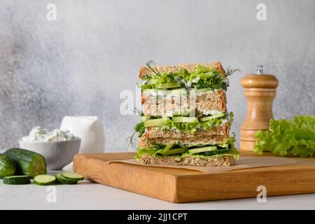 Englische Tee-Sandwiches mit Ricotta, Dill, Gurke auf grauem Hintergrund. Nahaufnahme. Stockfoto