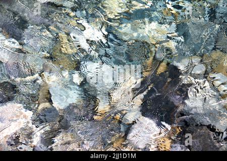 Klares Schmelzwasser direkt vom Gletscher mit Blick auf den Flussboden. Stockfoto