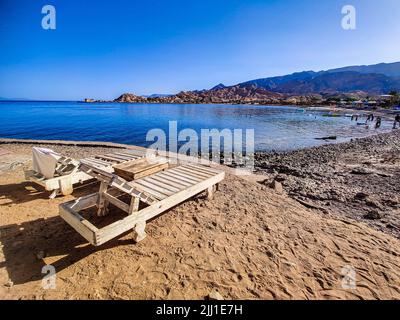 Ferienhaus in einem Beduinenlager am Meer in Ras Shitan in Oasis im Sinai, Taba Wüste mit dem Hintergrund des Meeres und der Berge. Stockfoto