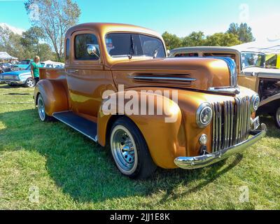 Chascomus, Argentinien - 09. Apr 2022: Alter goldener Ford Custom Hot Rod Pickup Truck 1942 - 1947 auf dem Land. Naturgrasbäume. Oldtimer-Show. Stockfoto