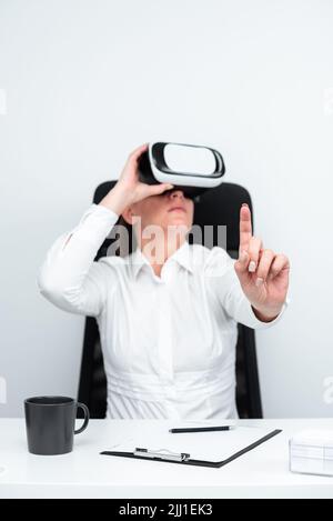 Geschäftsfrau Trägt Virtual Reality Brille Und Lernt Professionelle Fähigkeiten Durch Futuristische Simulation. Frau Gestikuliert, Während Sie Am Schreibtisch Sitzt Stockfoto