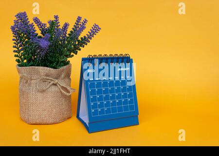 Januar 2023 Tischkalender mit Topfpflanze auf gelbem Hintergrund. Stockfoto