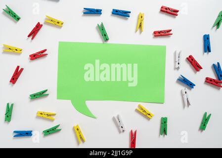 Bunte Haken, Die Um Die Sprechblase Mit Wichtigen Informationen Angeordnet Sind. Wooden Clips Arrangiert All Over Dialog Ballon Mit Crutial Idee. Stifte Mit Stockfoto