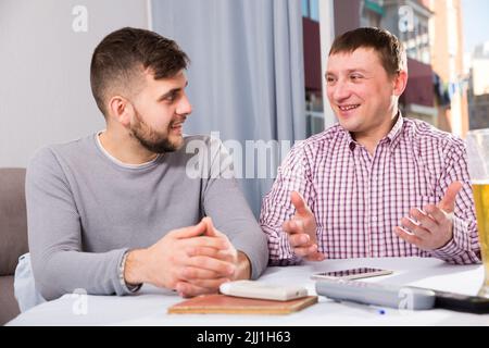 Männer unterhalten sich gerne am heimischen Tisch Stockfoto