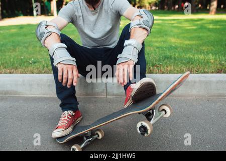 Nicht erkennbarer Skateboarder hat eine kurze Pause Stockfoto