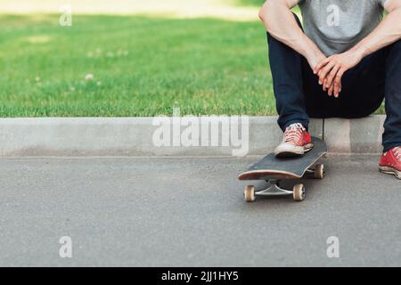 Unverkennbarer Hipster-Mann mit Skateboard Stockfoto