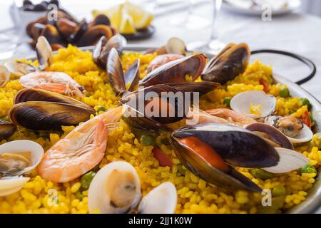 Meeresfrüchte Paella, berühmte Spanische Reisgericht in traditionellen Pfanne. Paella Valenciana mit rosa Garnelen, Muscheln und Muscheln auf safranreis mit vegetab Stockfoto