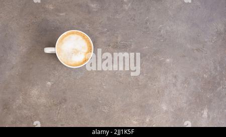Tasse Kaffee mit Schlagsahne auf Zementhintergrund für großes Banner. Stockfoto