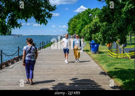 Menschen, die gemächlich den Bootswanderweg im Harbor Square Park am Hafen von Toronto, Ontario, Kanada, entlang gehen. Stockfoto
