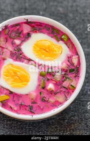 Kalte Rote Beete Suppe mit Eiern und frischem Gemüse. Im Sommer werden beliebte polnische und ukrainische Gerichte serviert Stockfoto