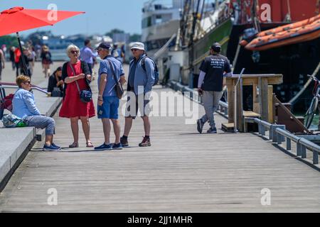 Touristen genießen sich auf der Promenade des Waterfront Trail im Hafen von Toronto neben dem festgetäuten Tall Ship Kajama, Ontario, Kanada. Stockfoto