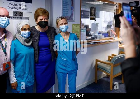 Die erste Ministerin Nicola Sturgeon (2. rechts) trifft ihre Mitarbeiter während eines Besuchs im Forge Medical Center in Parkhead, Glasgow. Bilddatum: Freitag, 22. Juli 2022. Stockfoto