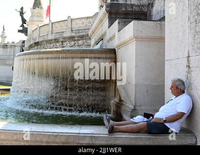 Rom, Italien. 22.. Juli 2022. Ein Mann erfrischt sich an einem Brunnen in Rom, Italien, 22. Juli 2022. Quelle: Alberto Lingria/Xinhua/Alamy Live News Stockfoto