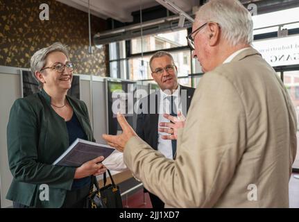 Gubin, Polen. 22.. Juli 2022. Klara Geywitz (SPD), Bundesministerin für Bau und Wohnen, und Rainer Genilke (M), Staatssekretär im Ministerium für Infrastruktur und Raumordnung Brandenburgs, Gespräch mit Florian Mausbach vom Verein zur Rekonstruktion der kriegszerstörten Villa des berühmten Architekten Mies van der Rohe während eines Besuchs der Ausstellung zum Projekt 'Rekonstruktion der Villa Wolf'. Quelle: Monika Skolimowska/dpa/Alamy Live News Stockfoto