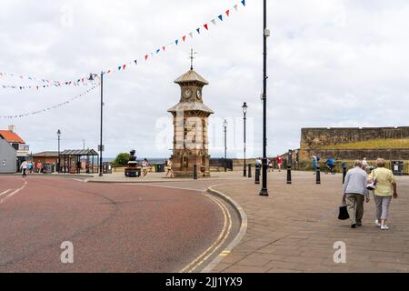 Ein Blick auf den alten Uhrenturm an der Front Street, Tynemouth Village, North Tyneside, Großbritannien, mit Touristen. Stockfoto