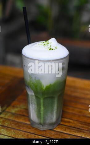 Matcha Latte auf Holztisch aus der Nähe Stockfoto