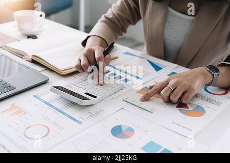 Asiatische Buchhalter arbeiten und analysieren Finanzberichte Projekt Buchhaltung mit Diagramm-Diagramm und Rechner in modernen Büro-, Finanz-und Geschäftsbereichen Stockfoto