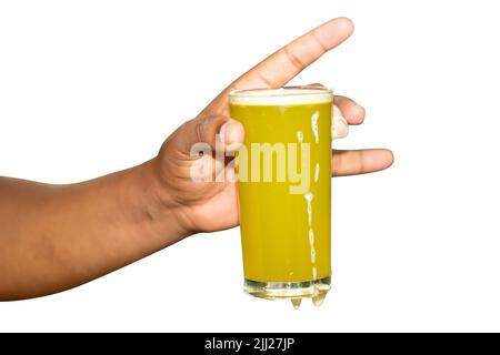 Eine männliche Hand, die ein Glas frischen Zuckerrohrsaft in einer Farm außerhalb von Bangladesch hält Stockfoto