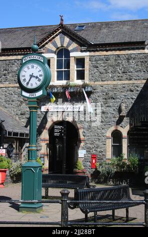 Blick auf die Uhr vor dem Eingang zum Bahnhof Betws-y-Coed in Nordwales, Juni 2022. Stockfoto