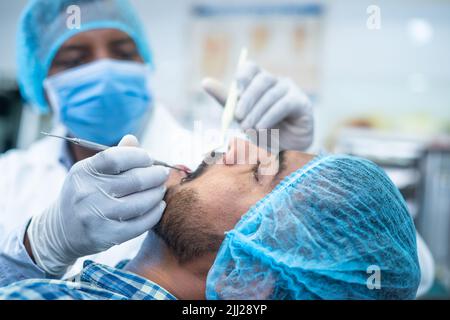 Fokus auf den Patienten Nahaufnahme des Zahnarztes Operationsoperation im Krankenhaus - Konzept der Zahnpflege, Zahnschmerzbehandlung und Beruf. Stockfoto