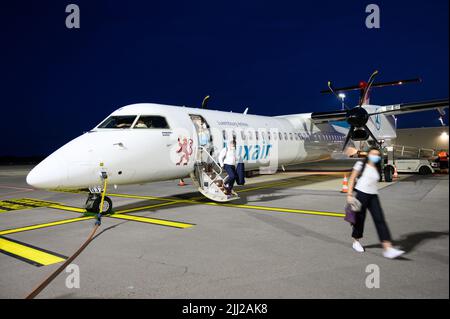 Passagiere, die am Flughafen Luxemburg ein gelandetes Flugzeug von Luxair (Luxembourg Airlines) (Bombardier Q400) aussteigen. Stockfoto