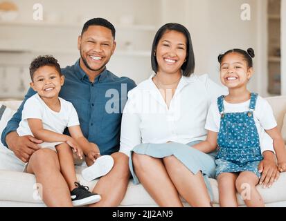 Familie ist für immer. Eine junge Familie verbindet sich glücklich auf dem Sofa zu Hause. Stockfoto