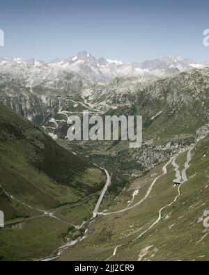 Der Furkapass und der Grimselpass in der Schweiz nahmen an einem klaren, sonnigen Tag vom Aussichtspunkt am Rhonegletscher mit Blick ins Tal auf Stockfoto