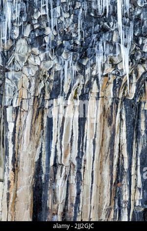 Eiszapfen aus dem Spray von Svartifoss, Island. Ein dünner, 20m-facher Wasserfall in der Mitte einer dramatischen Wand aus sechseckigen Basaltsäulen aus dem Jahr 3D. Stockfoto