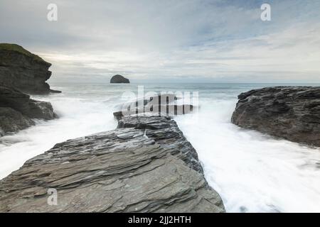 Wellen über den Felsen bei Trebarwith Strand, Cornwall, England, Großbritannien Stockfoto