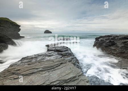 Wellen über den Felsen bei Trebarwith Strand, Cornwall, England, Großbritannien Stockfoto