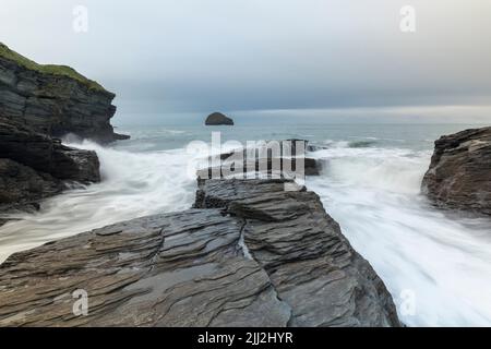 Wellen über den Felsen bei Trebarwith Strand, Cornwall, England, Großbritannien Stockfoto