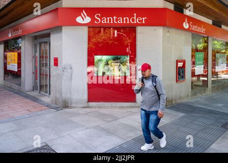 Ein Fußgänger geht an der spanischen multinationalen Geschäftsbank und den Finanzdienstleistungen der Santander-Niederlassung vorbei, die in Spanien zu sehen ist. Stockfoto