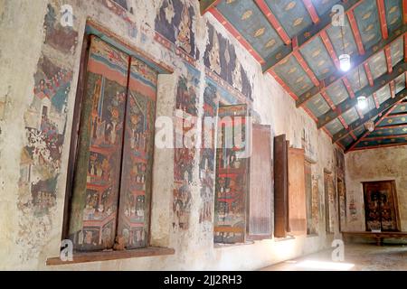 Erstaunliche alte Wandkunst und Gemälde auf hölzernen Fensterpaneelen in der Predigthalle des Wat Choeng Tha Tempels, Ayutthaya, Thailand Stockfoto