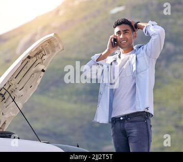 Mein Auto ist gerade kaputt gegangen. Ein hübscher junger Mann am Telefon mit Pannenhilfe, nachdem er einen Fahrzeugausfall erlitten hatte. Stockfoto