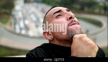Nachdenklicher Mann in der Innenstadt, der am Himmel denkt Stockfoto
