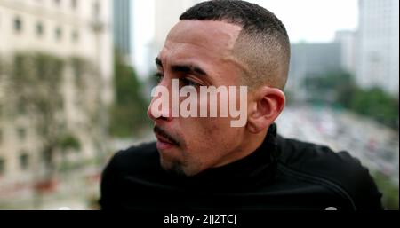 Nachdenklicher hispanischer Mann, der in der Innenstadt denkt Stockfoto