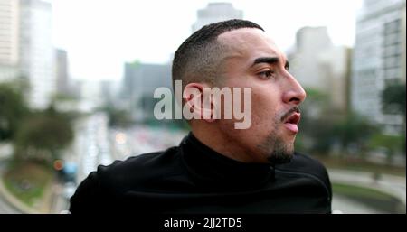 Nachdenklicher hispanischer Mann, der in der Innenstadt denkt Stockfoto