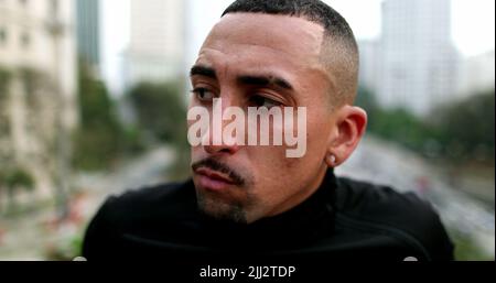 Nachdenklicher hispanischer Mann, der in der Innenstadt denkt Stockfoto