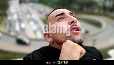 Nachdenklicher Mann in der Innenstadt, der am Himmel denkt Stockfoto