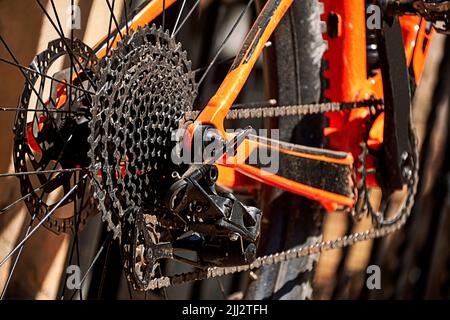 Hinterrad, Rad- und Kettenräder für Fahrräder. Orange und schwarz, unscharfem Hintergrund, Pedal Stockfoto