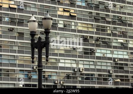 Ehemaliger öffentlicher Lichtmast am Viadukt von Santa Ifigenia mit Fenstern im Bürogebäude in Sao Paulo. Stockfoto