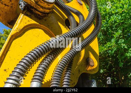 Hydraulikschläuche am Schaufelarm eines Radladers zur Kraftübertragung zum Baggerbehälter Stockfoto